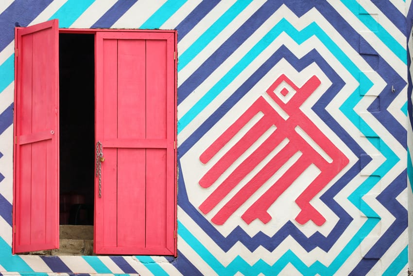 Mural geométrico maya con puerta rosa en Santa Catarina