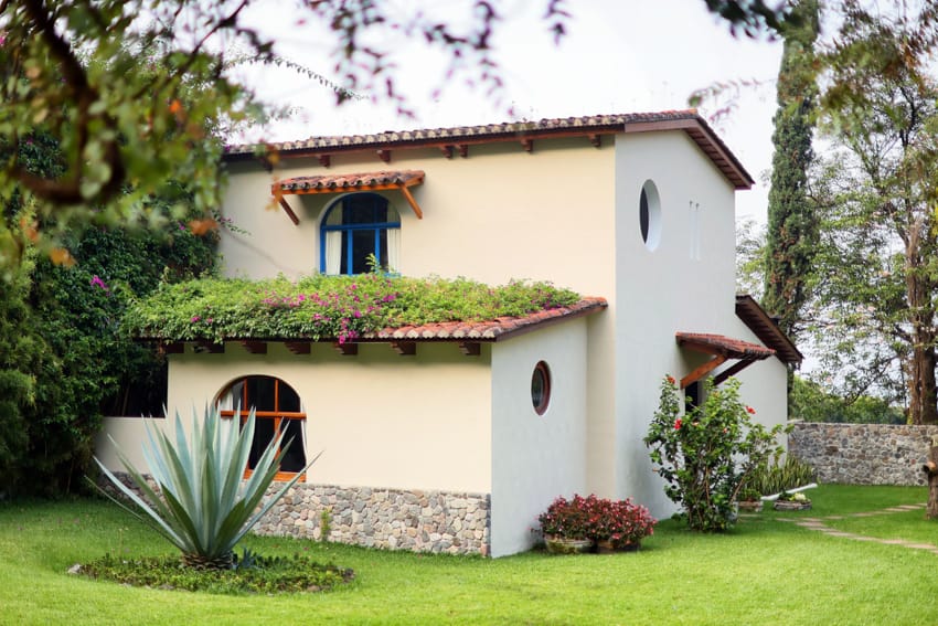 Bungalow colonial con techo verde, agave y jardines
