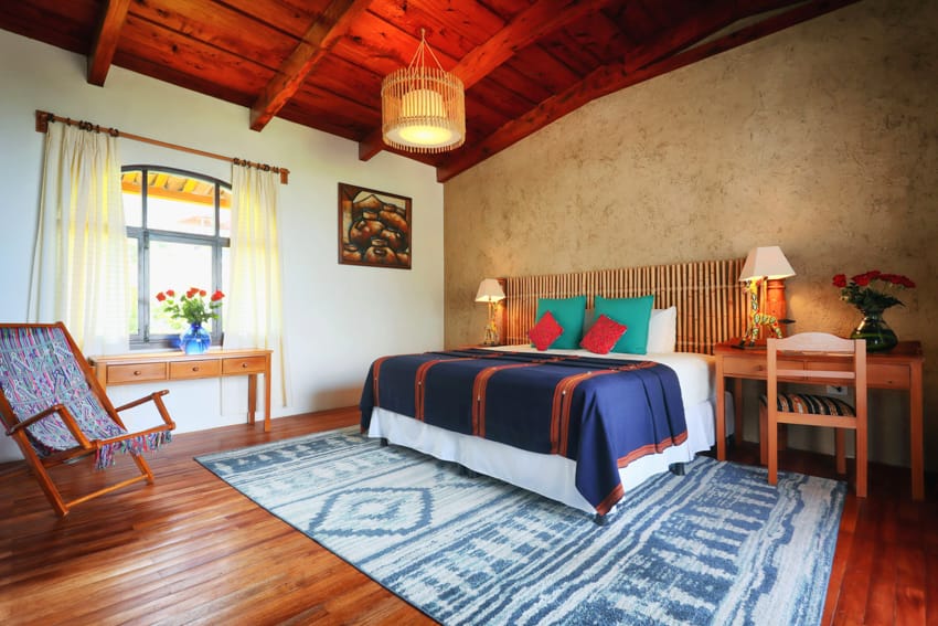 Junior Suite con cama king, textiles azules, silla hamaca