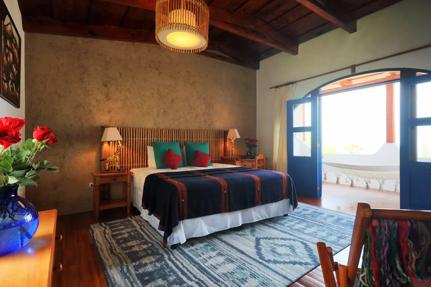 Junior Suite con puerta azul abierta al balcón con hamaca