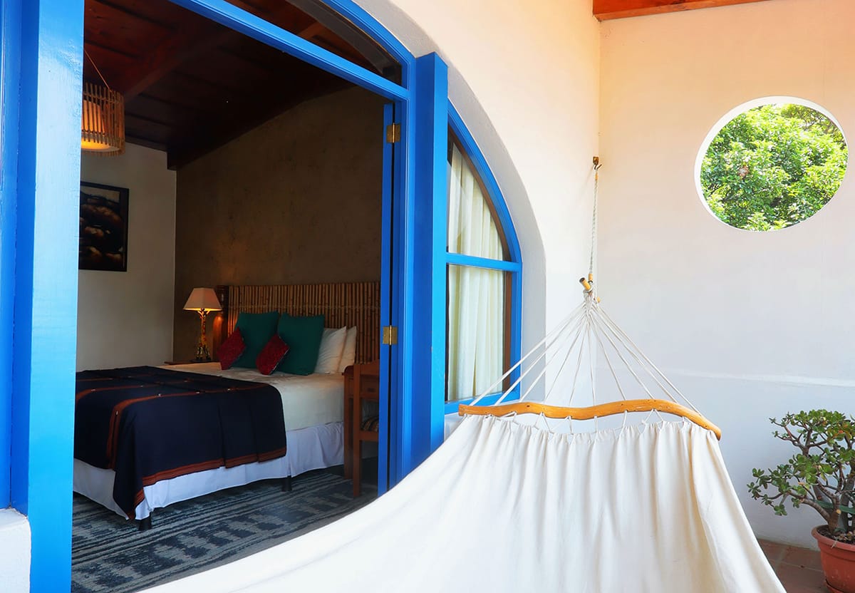 Junior Suite con puerta azul ad arco, hamaca y vista