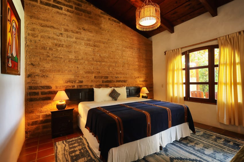 Habitación standard con pared de ladrillo, cama king azul