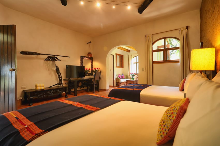 Habitación triple deluxe con dos camas y arco al salón