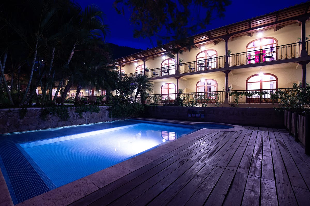 Piscina con deck de madera e iluminación azul neon