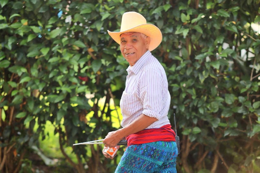 Jardinero sonriente con sombrero y faja roja
