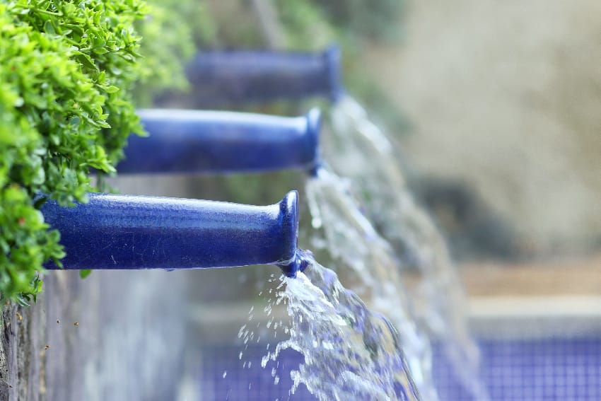 Fuentes de agua azul cayendo en la piscina