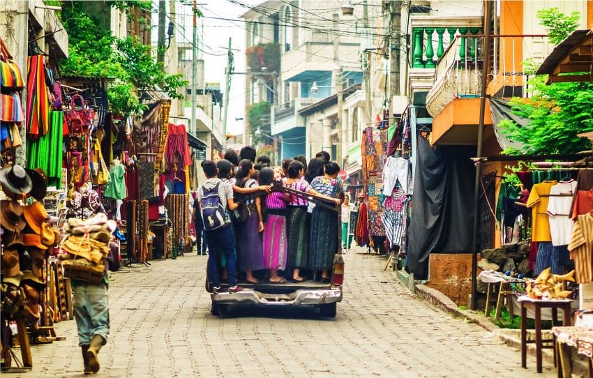 Calle de mercado con mujeres mayas en camioneta